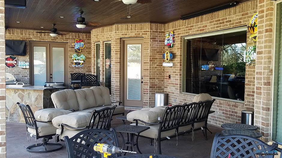 View of back patio with furniture neon bar signs and TV Projector with motorized screen.